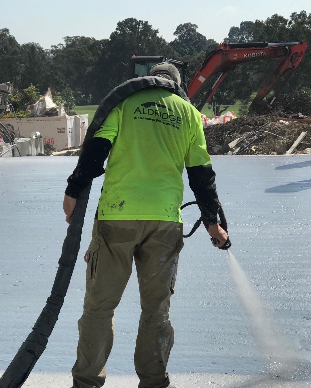 All Seasons applicator spraying a waterproofing membrane on a development site