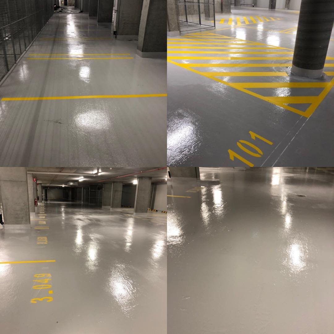 Grey epoxy floor coating with yellow line marking in a basement carpark